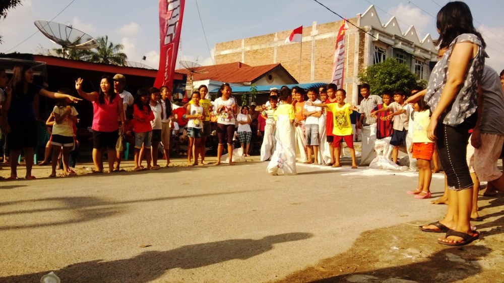 Balap karung. Menjelang garis finish disambut sorakan penonton, bagaikan juara di motoGP ya hehe